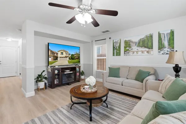 a living room with furniture a fireplace and a flat screen tv