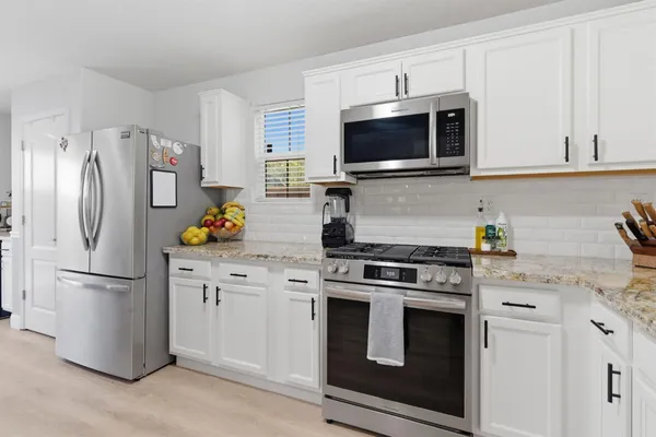 a kitchen with stainless steel appliances a stove microwave and refrigerator