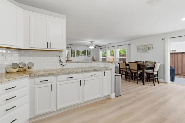 a kitchen with granite countertop cabinets a dining table and chairs