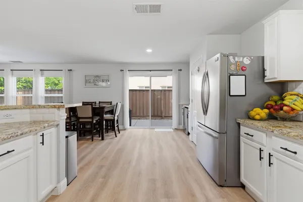 a kitchen with stainless steel appliances granite countertop a refrigerator and a stove top oven