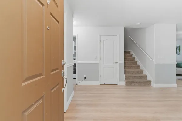 a view of a hallway with wooden floor and entryway