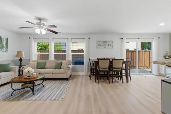 a living room with furniture dining table and a large window