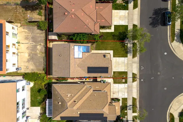 an aerial view of a house with garden space and car parked