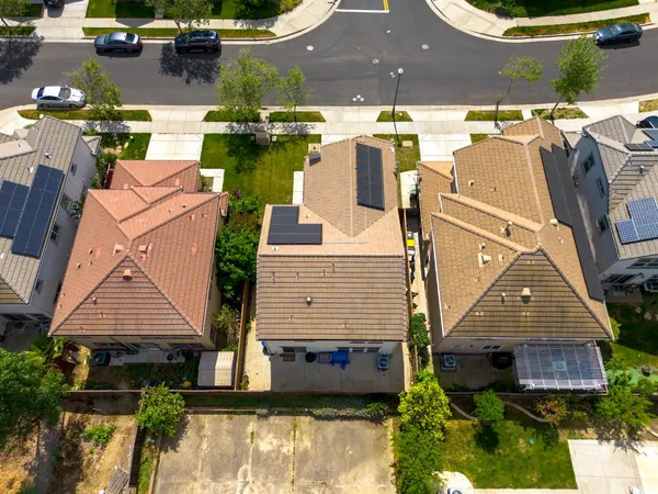 an aerial view of a house with a garden and lake view