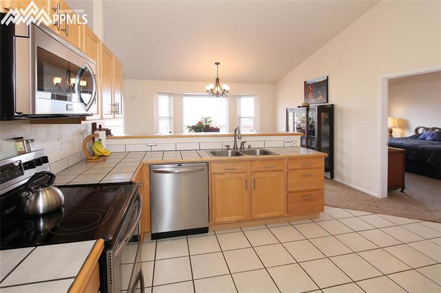 11720 Denver Road Peyton, CO 80831 - Photo 4 of 11 Stainless steel appliances and tile counters and floor