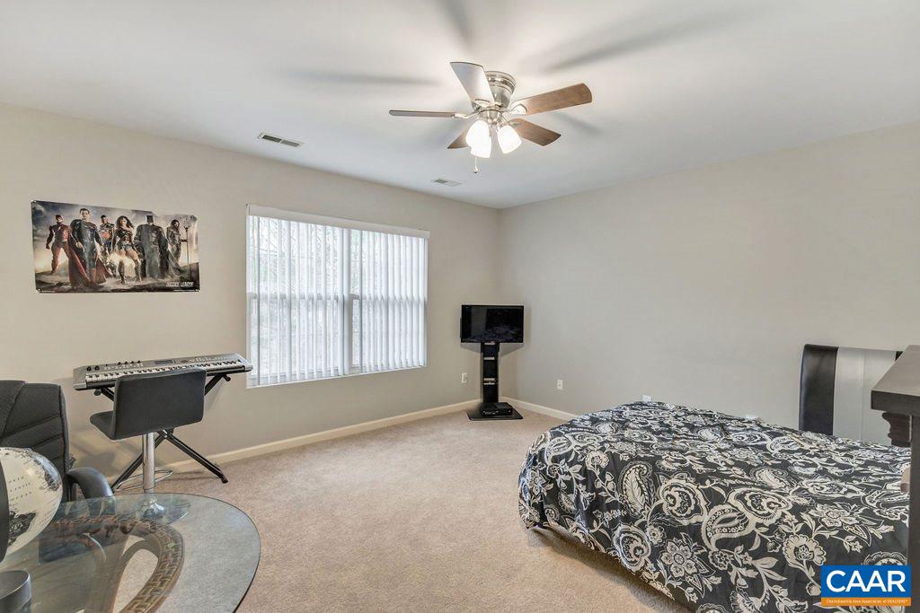 38 Amethyst Road Palmyra, VA 22963 - Photo 21 of 45 a bedroom with a bed and a chandelier