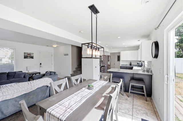 5485 Heather Way Tooele, UT 84074 - Photo 19 of 41 Open-concept living space featuring a dining area, kitchen island with seating, and sliding glass door
