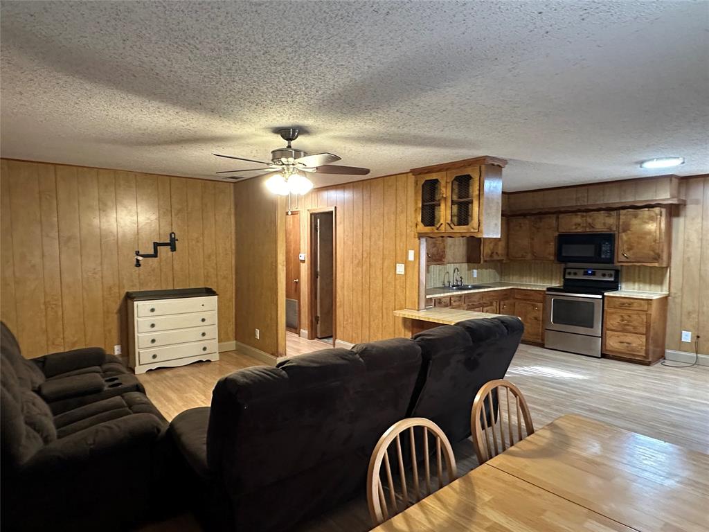 102 7th Street Celeste, TX 75423 - Photo 3 of 10 a view of a livingroom with furniture a flat screen tv and kitchen view