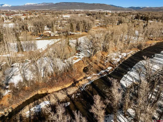 a front view of a house with a yard covered with snow