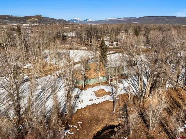 a view of a backyard with snow on the road