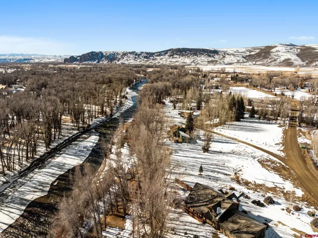 a view of a white house with a yard and sitting area