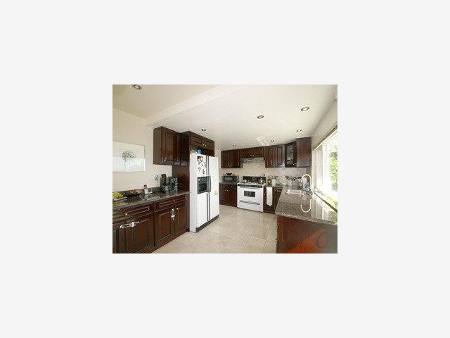 1807 Randall Road San Mateo, CA 94402 - Photo 5 of 9 a kitchen with stainless steel appliances kitchen island granite countertop a refrigerator oven a sink dishwasher with a dining table and chairs