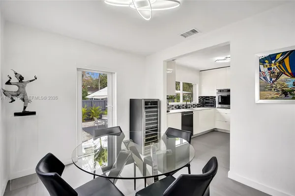 a dining room with furniture a kitchen view and wooden floor
