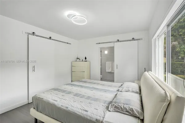 a bedroom with a large bed and a chandelier