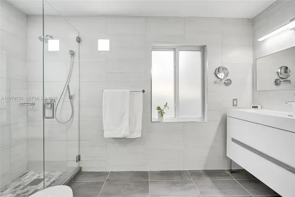 a bathroom with a shower sink and mirror