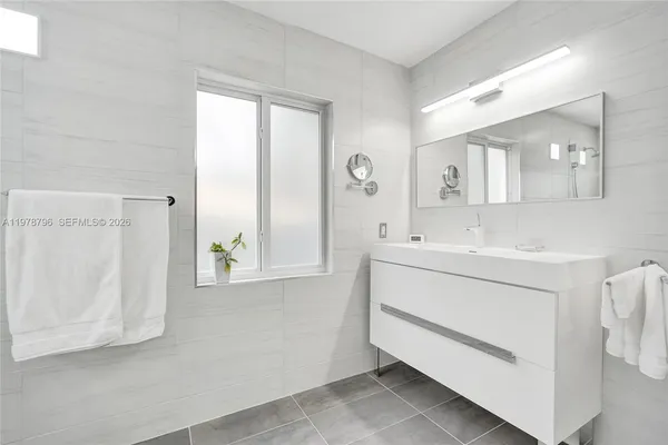 a bathroom with a sink a mirror and a window