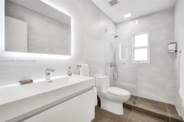 a bathroom with a toilet a sink and mirror