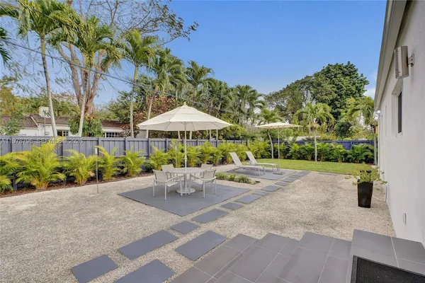 a view of a patio with a table and chairs under an umbrella