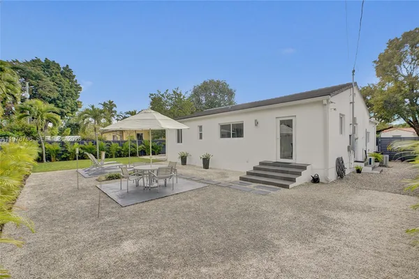 a view of a house with backyard and a tree
