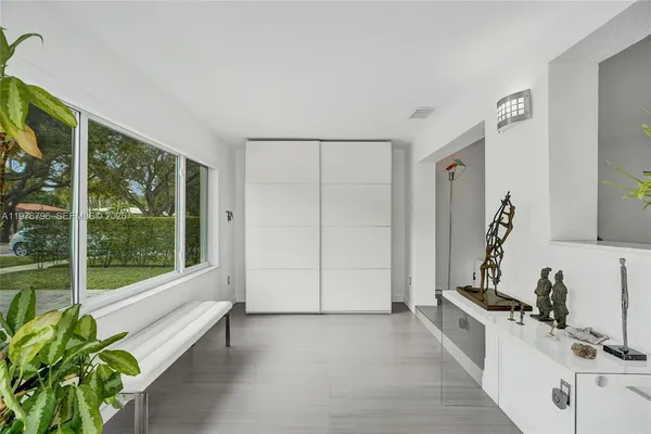a large white room with a large window and a rug
