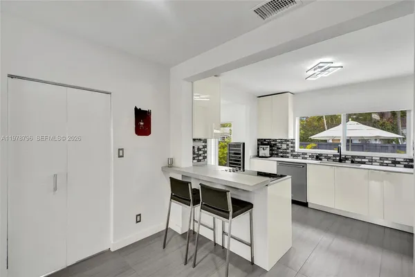 a kitchen with stainless steel appliances a table and chairs in it