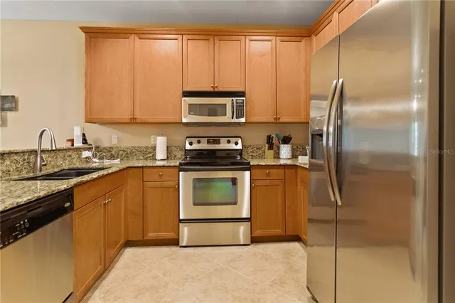 a kitchen with a refrigerator sink and cabinets