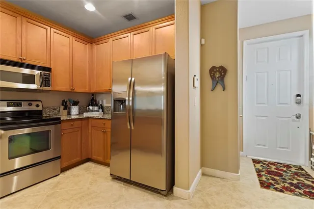 a kitchen with stainless steel appliances granite countertop a refrigerator a stove and a sink