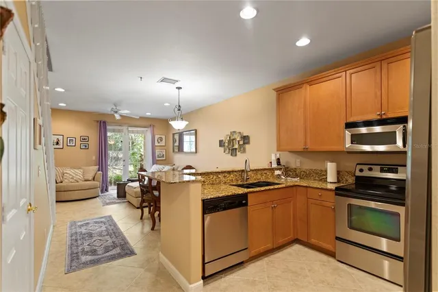 a kitchen with stainless steel appliances granite countertop a stove a sink dishwasher and a refrigerator