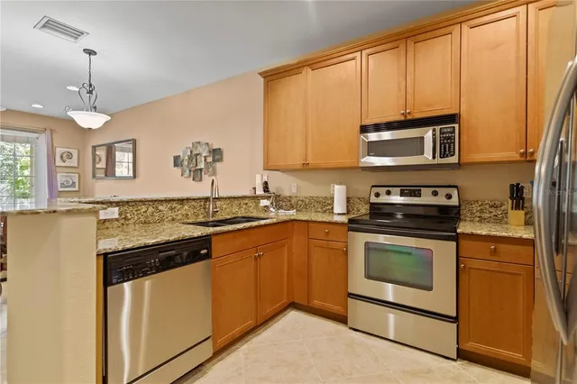 a kitchen with stainless steel appliances granite countertop a stove a sink and a microwave