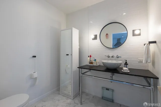 a bathroom with a toilet a sink and a mirror