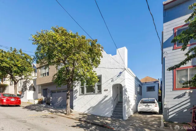 a front view of a house with barbeque grill and plants