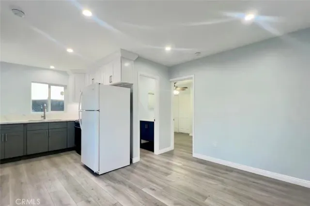 a view of a kitchen with a refrigerator and a sink