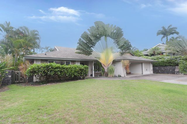 front view of a house with a yard and potted plants