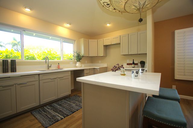 a kitchen with a sink a window and cabinets