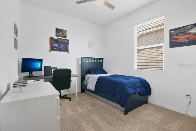 a bedroom with a bed and a computer on the desk