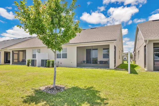a view of a house with a patio and a yard