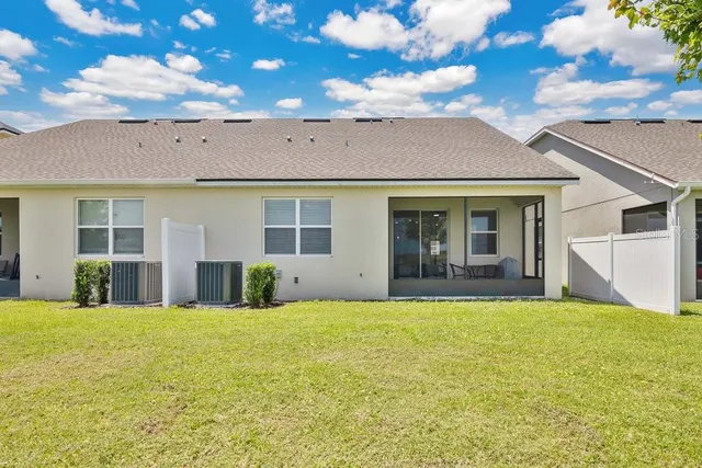 a view of a house with a big yard and large tree