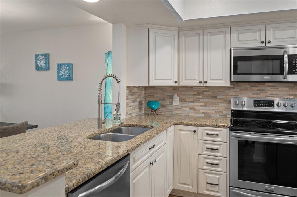 8211 Brent Street, Unit 847 Port Richey, FL 34668 - Photo 11 of 29 a kitchen with granite countertop a sink stove and cabinets
