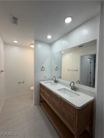 a white toilet sitting next to a white wall