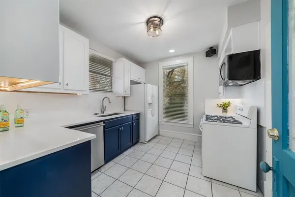 a kitchen with stainless steel appliances a stove microwave and sink
