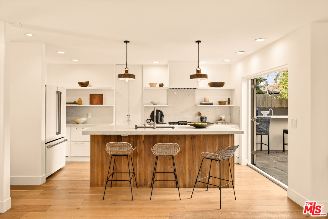 3128 Stanford Avenue Venice, CA 90292 - Photo 9 of 43 a kitchen with kitchen island stainless steel appliances a dining table chairs sink and cabinets