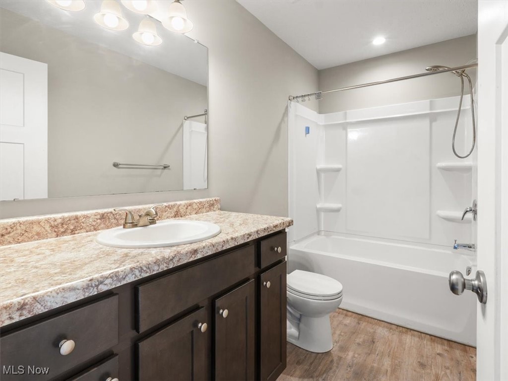 5525 White Road Geneva, OH 44041 - Photo 20 of 28 Full bathroom with vanity, tub / shower combination, toilet, and hardwood / wood-style floors