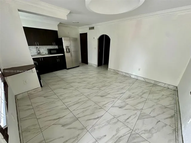 a view of kitchen with refrigerator and cabinets