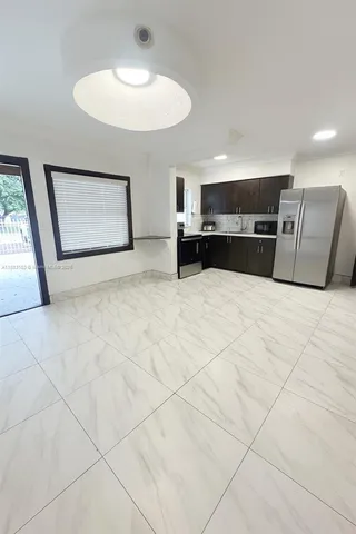 a view of an empty room with cabinet and a window