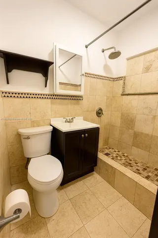 a bathroom with a granite countertop toilet sink and mirror