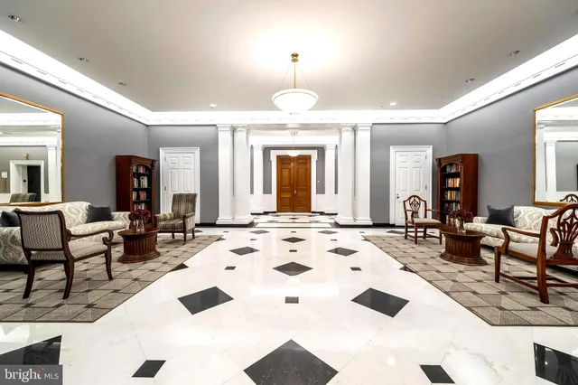 a living room with furniture a chandelier and a dining table