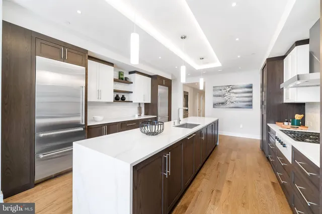 a large kitchen with stainless steel appliances a sink and a refrigerator
