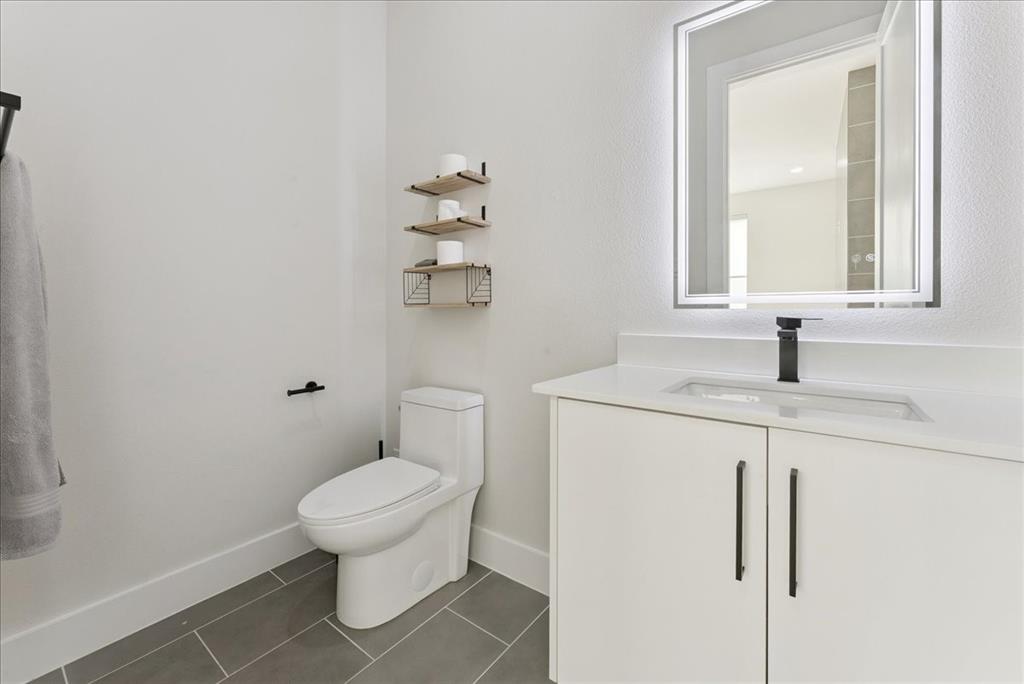 1512 Seegar Street, Unit 101 Dallas, TX 75215 - Photo 17 of 31 a bathroom with a toilet sink and mirror