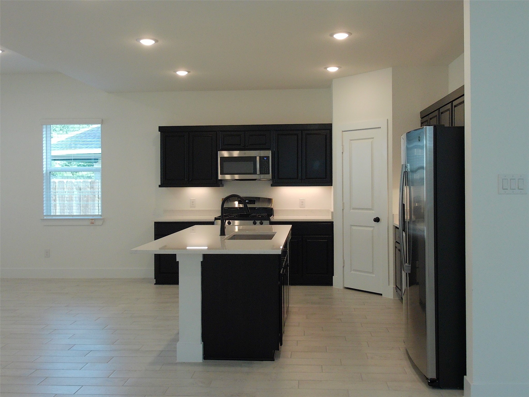 19293 Hazel Firs Court Magnolia, TX 77355 - Photo 4 of 36 a kitchen with kitchen island stainless steel appliances a sink stove and refrigerator
