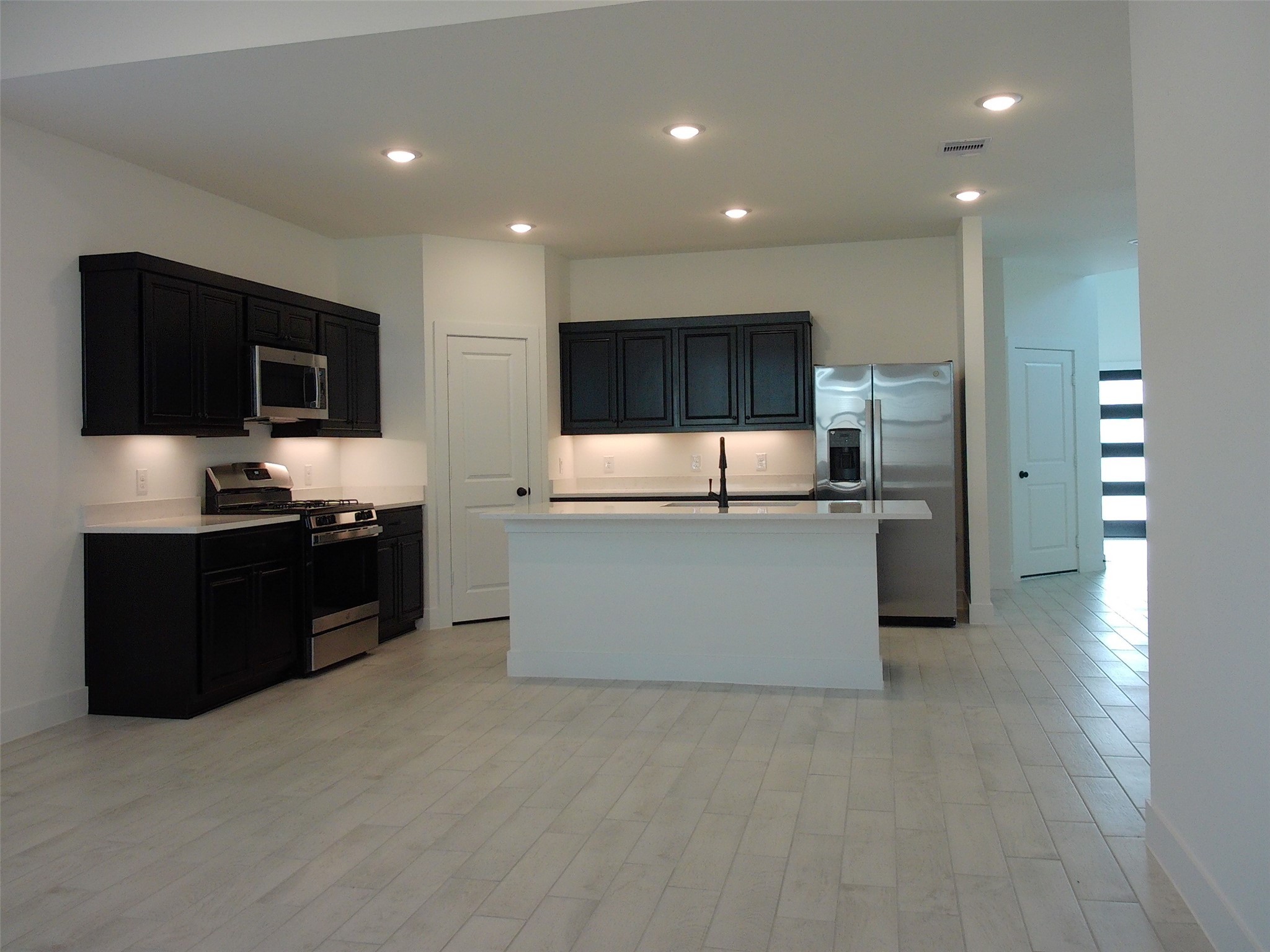 19293 Hazel Firs Court Magnolia, TX 77355 - Photo 7 of 36 a large kitchen with stainless steel appliances a large counter top a stove and a refrigerator